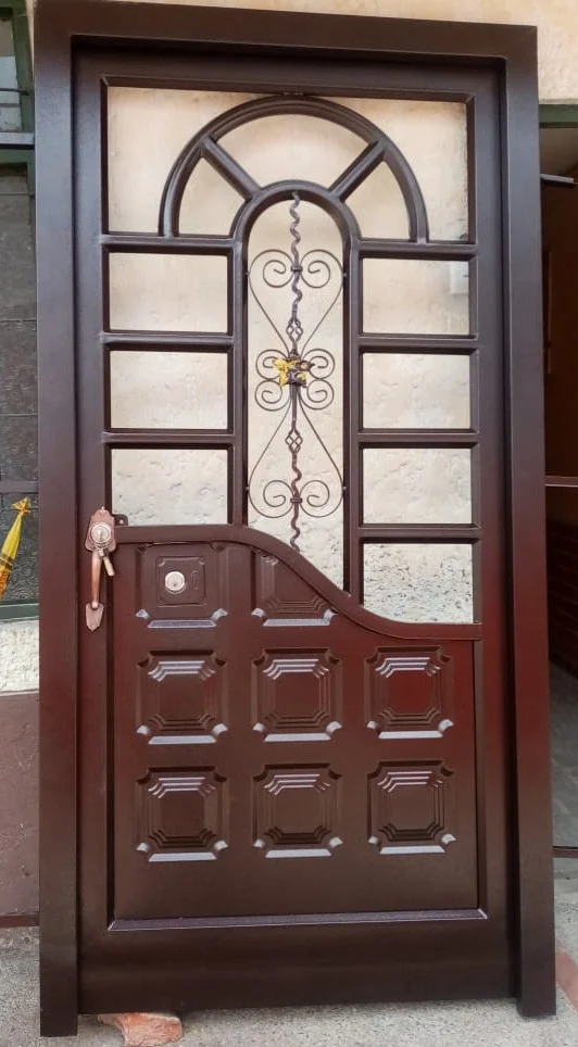Puerta con arco y forja decorativa