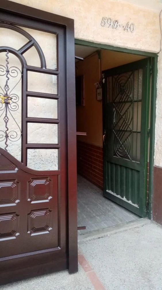 Puerta de entrada con reja y tablero