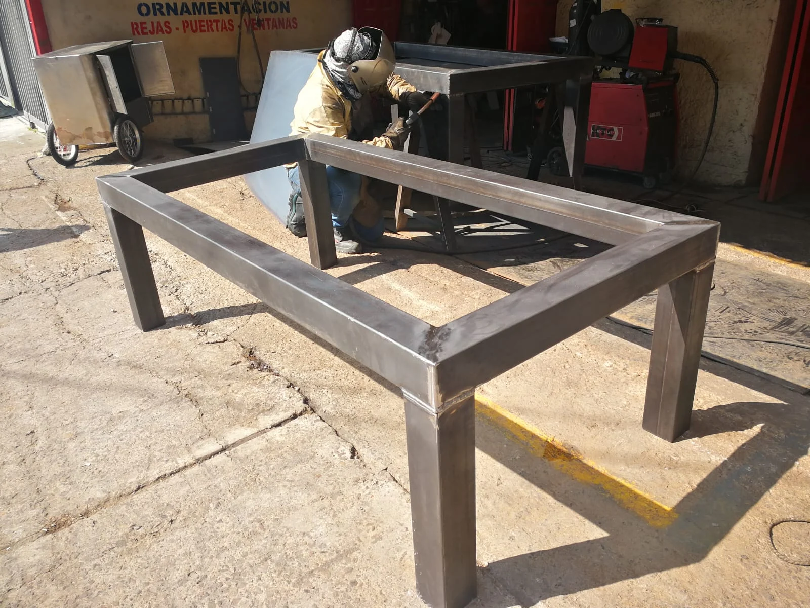 Soldador armando la estructura de una mesa en el taller